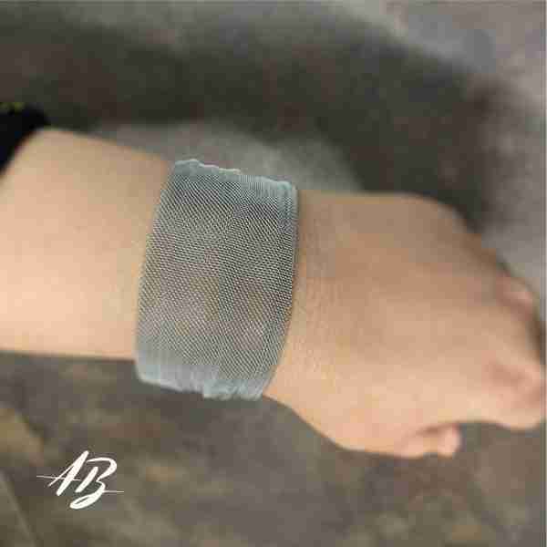 Pulsera tejida de malla de acero con cierre de imán.